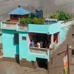 Family survives as powerful Nepal floodwaters destroy surrounding structures nearby.