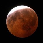 Skywatchers witness dramatic lunar eclipse reaching maximum shortly after midnight