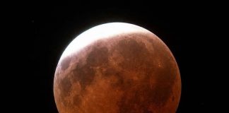 Skywatchers witness dramatic lunar eclipse reaching maximum shortly after midnight