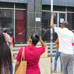 People unable to cash government cheques gather outside Treasury Building