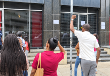 People unable to cash government cheques gather outside Treasury Building