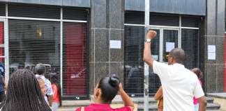 People unable to cash government cheques gather outside Treasury Building