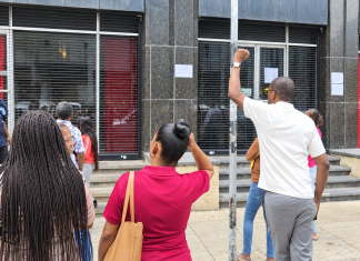 People unable to cash government cheques gather outside Treasury Building