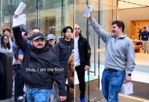Crowd cheers as excited iPhone buyer celebrates supposed worldwide first.